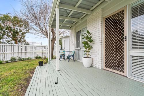 a woman sitting on the porch of a house at Number 9 in Portarlington