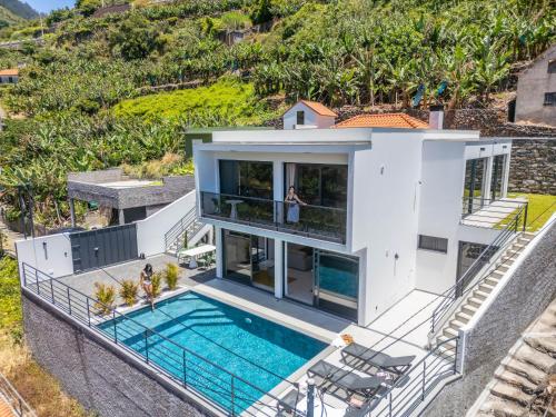 an aerial view of a house with a swimming pool at Atlantic Pebble Villa in Ribeira Brava