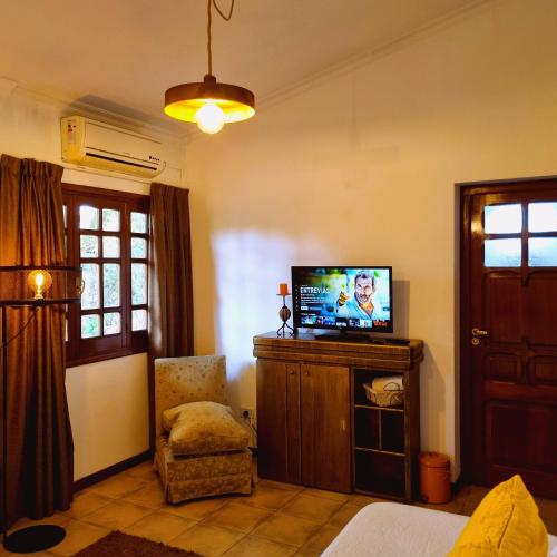 a living room with a tv and a chair at Posada El Prado in Salta