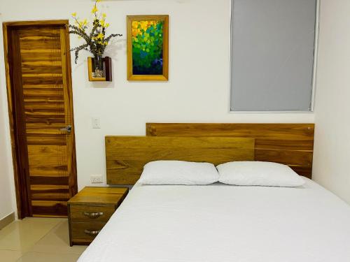 a bedroom with a bed with two white pillows at Hotel ESI Apartado in Apartadó