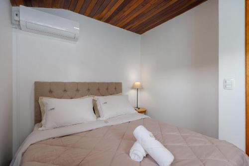 a bedroom with a large bed with white pillows at Casa Sonnendorf 4 dorm Centro by Achei Gramado in Gramado