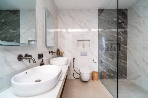 a white bathroom with a sink and a shower at Jago Gili Air in Gili Islands