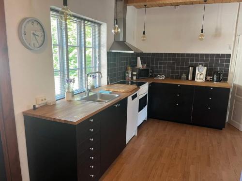 a kitchen with a sink and a clock on the wall at 6 person holiday home in Løkken in Løkken