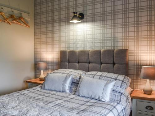a bedroom with a bed with two pillows and two lamps at Gable End Cottage in Ingleton 