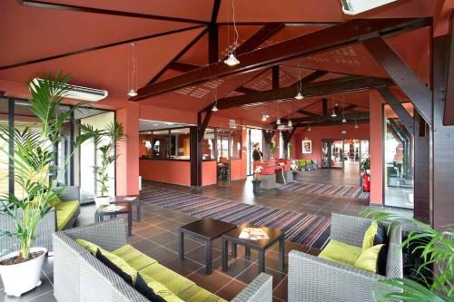 a lobby with couches and tables in a building at ibis Styles Segre in Segré