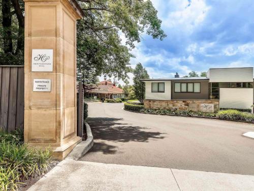 a house with a sign on the side of a driveway at The Sebel Bowral Heritage Park in Bowral