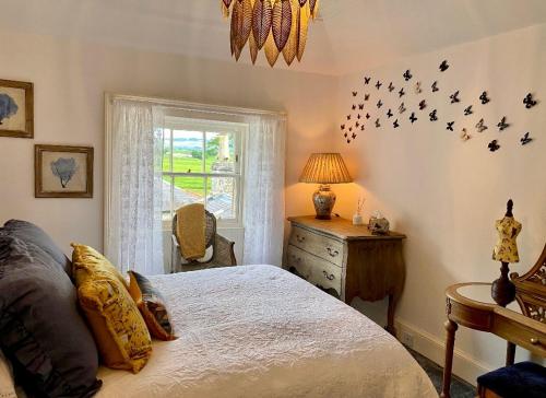 a bedroom with a bed and a window at Spacious 3-Bed Manor & Jacuzzi & BBQ Cabin in Maybole