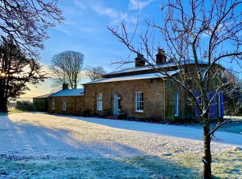 an old brick house with snow on the ground at Spacious 3-Bed Manor & Jacuzzi & BBQ Cabin in Maybole