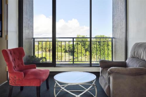 a living room with a couch and a table and a window at SureStay by Best Western Guam Airport in Tamuning