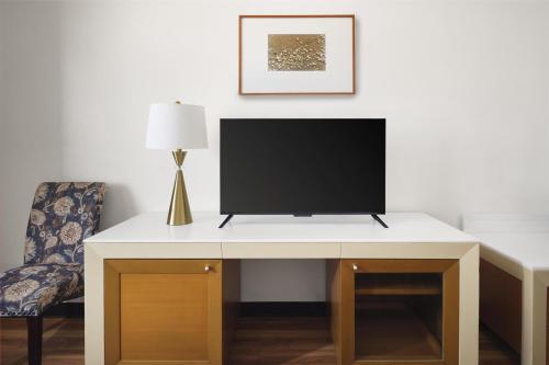 a white desk with a television on top of it at SureStay by Best Western Guam Airport in Tamuning