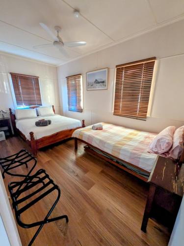 a bedroom with two beds and a fan at 3 bed cottage nestled at centre of 21 acres in Blackbutt in Blackbutt