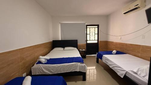 a bedroom with two beds and a window at Quinta de San Pedro in Villavicencio