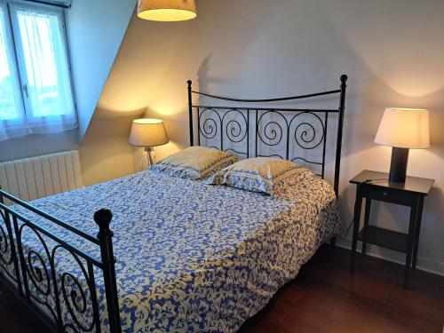 a bedroom with a bed and two lamps on tables at Holiday Home in France near Sandy Beaches in Guissény