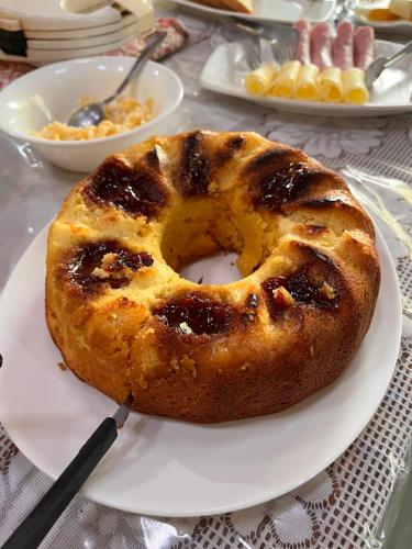 a cake sitting on a white plate on a table at Quintal De Minas in Delfinópolis