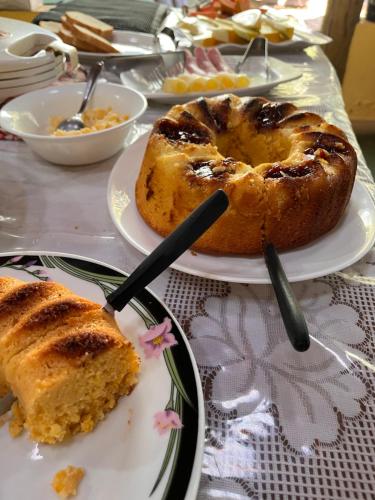 a table with two plates of bread and a piece of cake at Quintal De Minas in Delfinópolis