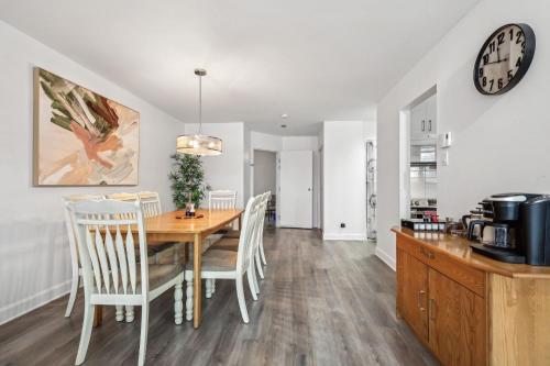 a dining room with a table and chairs and a clock at Big Sunshine in Mont-Tremblant
