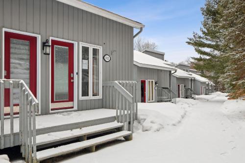 a house with red doors in the snow at Big Sunshine in Mont-Tremblant