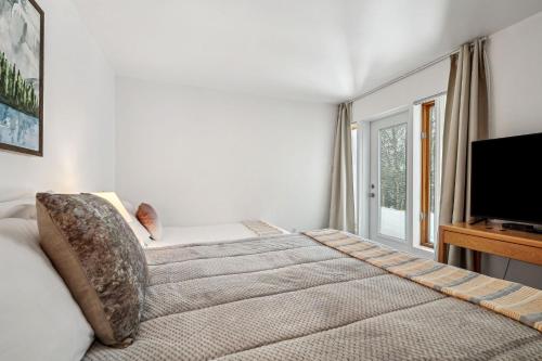 a bedroom with a bed and a flat screen tv at Big Sunshine in Mont-Tremblant
