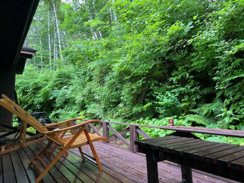 a wooden chair sitting on a wooden deck at Konashi No Yu Sasaya in Matsumoto