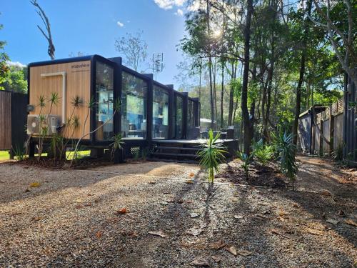 a glass house in the middle of a forest at Coastal Bliss New Brighton Eco Pod 50m to Beach in New Brighton