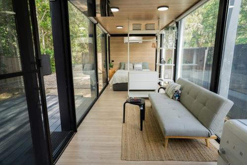 a living room with a couch and a bed at Coastal Bliss New Brighton Eco Pod 50m to Beach in New Brighton