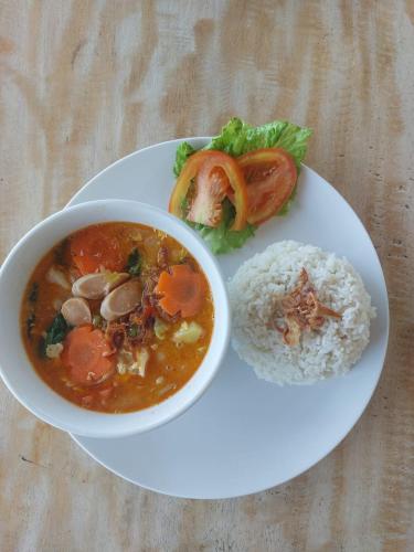 a plate of food with a bowl of soup and rice at Innora Jungle Resort And Spa in Nusa Penida