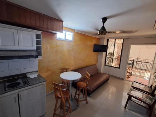 a kitchen and living room with a table and a couch at Apartaestudio en el Rodadero junto al mar in Gaira