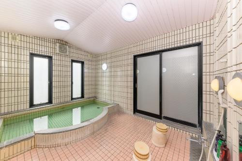 a bathroom with a tub and a swimming pool at 美祢グランドホテル in Mine