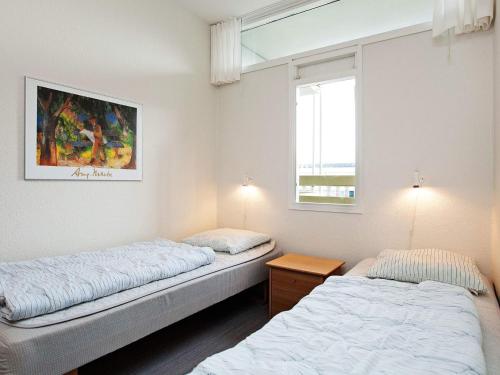 Dos camas en una habitación con ventana. en Inviting holiday home in Fanø, en Fanø