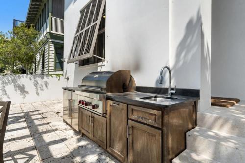 a outdoor kitchen with a sink and a stove at Rosemary Bluegrass in Rosemary Beach