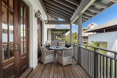 a patio with a table and chairs on a deck at Rosemary Bluegrass in Rosemary Beach