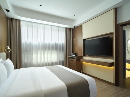 a hotel room with a bed and a flat screen tv at Lumina Boutique Hotel in Zhangjiajie