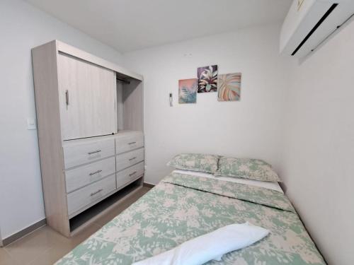 a bedroom with a bed and a dresser at Vacaciones Inolvidables in Coveñas