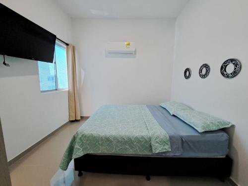 a bedroom with a bed and a flat screen tv at Vacaciones Inolvidables in Coveñas