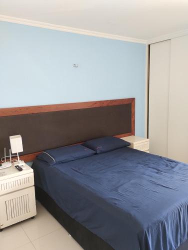 a bedroom with a bed with a blue comforter at Eco Paradise 213 in Cumbuco