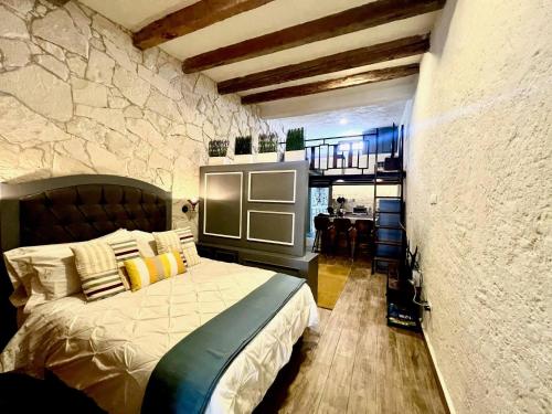a bedroom with a bed and a stone wall at Amore e Vino en ValQuirico in Santeagueda