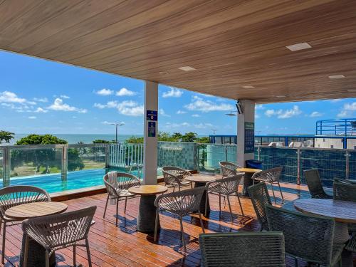 a patio with tables and chairs and a pool at Israel Flat Tambaú - 315 in João Pessoa