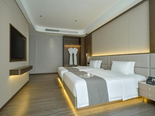 a bedroom with a large white bed and a television at Lumina Boutique Hotel in Zhangjiajie