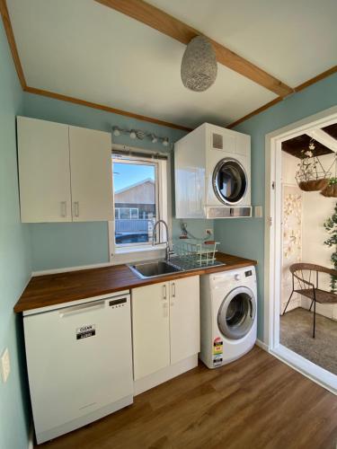 a kitchen with a sink and a washing machine at Sun-kissed Spa Retreat in Hastings