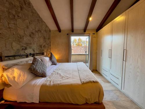 a bedroom with a bed and a stone wall at Arena en ValQuirico in Santeagueda