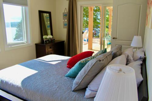 ein Schlafzimmer mit einem Bett mit Kissen und einem Fenster in der Unterkunft Whitecaps Retreat Beach House 