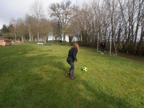 a young girl playing with a soccer ball in a field at Maison de charme avec grand jardin, proche Haras du Pin, animaux acceptés, idéale pour familles - FR-1-497-5 in Saint-Pierre-la-Rivière