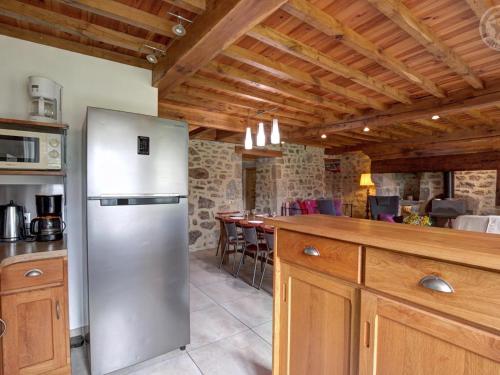 a kitchen with a stainless steel refrigerator and a bar at Gîte de charme avec cheminée, jardin et espaces détente - idéal famille et amis, draps fournis - FR-1-496-44 in La Valla