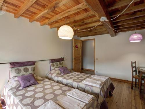 a bedroom with two beds and a table and chairs at Gîte de charme avec cheminée, jardin et espaces détente - idéal famille et amis, draps fournis - FR-1-496-44 in La Valla