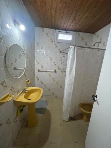 a bathroom with a yellow sink and a toilet at Casa de chacra in Veinticinco de Mayo