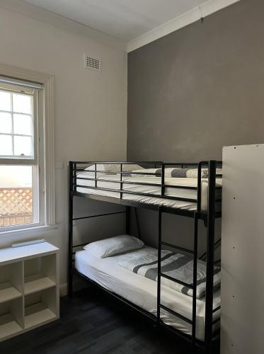 two bunk beds in a room with a window at Manly Bunkhouse in Sydney