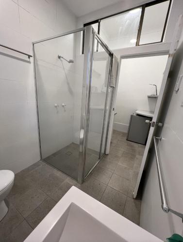 a bathroom with a shower and a toilet at Manly Bunkhouse in Sydney