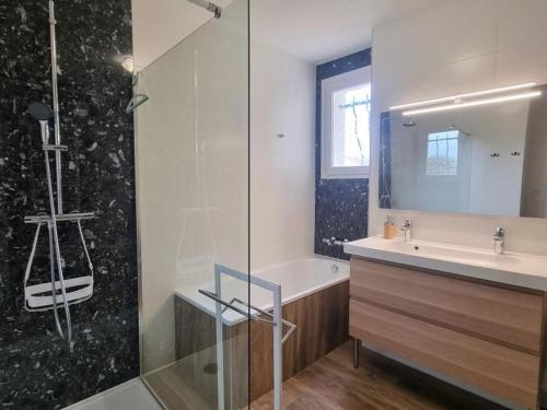 un bagno con lavandino e doccia in vetro di Gîte spacieux avec terrasse, cheminée, wifi et parking à Roanne - FR-1-496-337 a Roanne