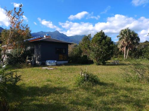 a small house in the middle of a field at Green Cottage ＭＭ in Yakushima