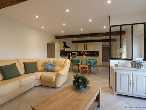 un salon avec un canapé et une table dans l'établissement Maison ancienne avec jardin, terrasse, wifi et équipements bébé - idéal pour découvrir la Normandie - FR-1-497-160, à Nécy